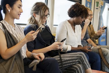 Woman Sitting While Holding Phone