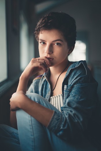 Woman Sitting While Right Hand on Lips