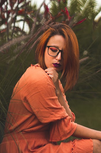 Woman Sitting While Wearing Orange Dress