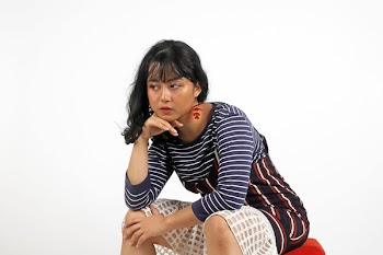 Woman Sitting With Hand on Chin