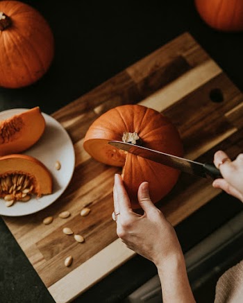 Woman slicing pumpkin for Thanksgiving dinner food photography
