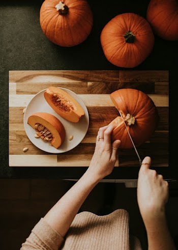 Woman slicing pumpkin for Thanksgiving dinner food photography