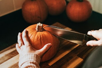 Woman slicing pumpkin for Thanksgiving dinner food photography
