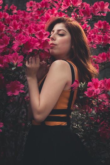 Woman smelling red flowers
