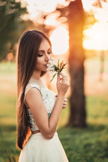 Woman Smelling White Flowers