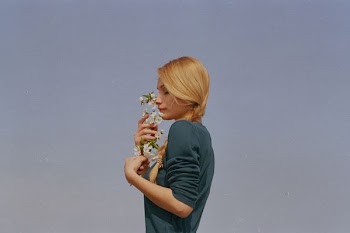 woman smelling white petaled flowers