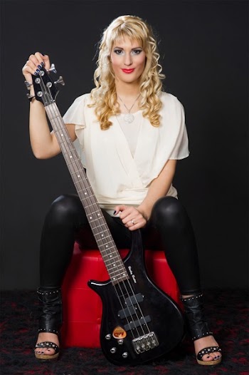 Woman Smiling and Holding Black Electric Guitar