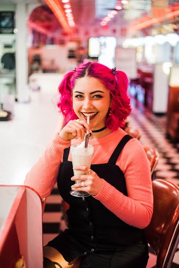 Woman Smiling and Holding Drink With Straw