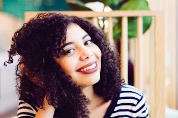 woman smiling and holding her hair
