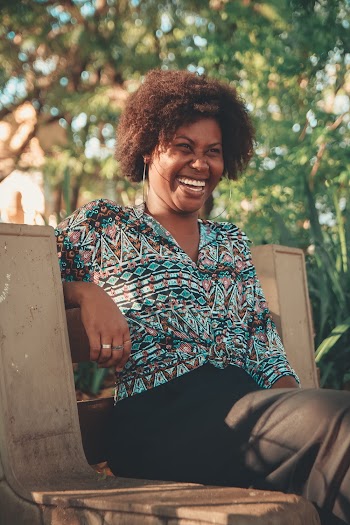 Woman Smiling and Sitting on Bench