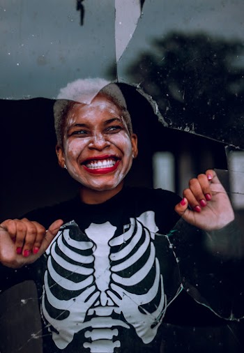 Woman Smiling Behind Broken Glass Window