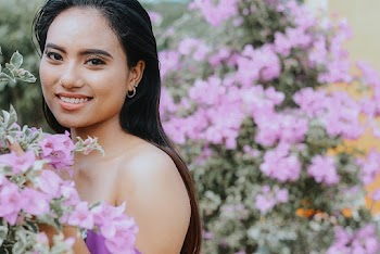 Woman Smiling Beside Pink Flowers