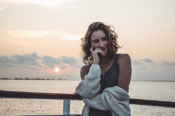Woman Smiling Beside Railing during Golden Hour