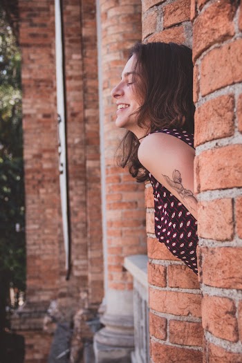 Woman Smiling Between Concrete Pillars