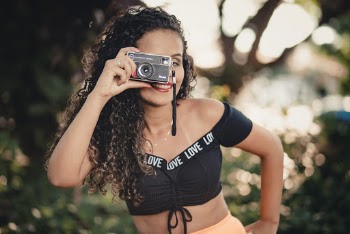 Woman Smiling Holding Camera