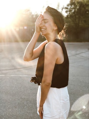 Woman Smiling Putting Her Hand on Her Eye