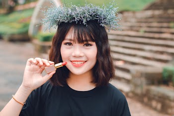 Woman Smiling While Holding Lipstick