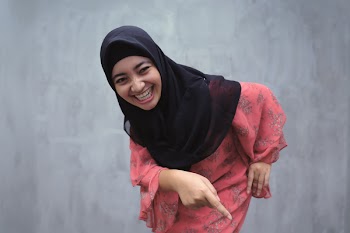 Woman Smiling While Laughing and Pointing on Her Waist