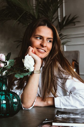 Woman Smiling While Leaning on Table