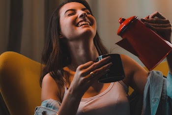 Woman Smiling While Pouring Beverage On Mug