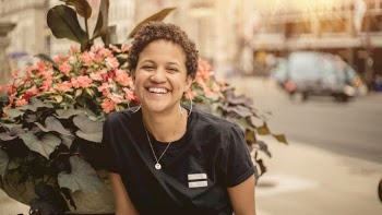 Woman Smiling While Standing Beside Flowers