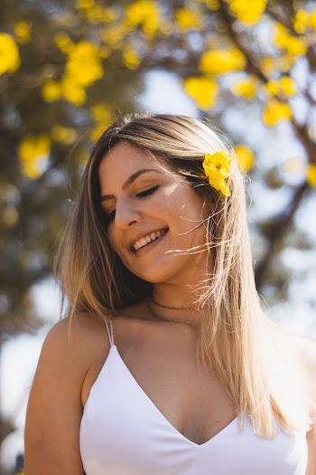 Woman Smiling With Yellow Flower on Her Hair