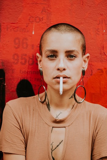 Woman Smoking Near Wall