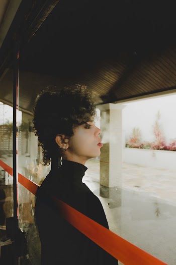 Woman Smoking On The Outside Of A Glass Wall