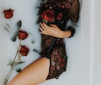 woman soaked in water while holding rose