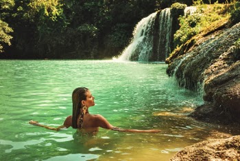 Woman Soaking in water near Waterfalls
