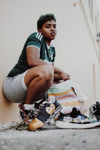 Woman Squatting And Leaning Against Wall 