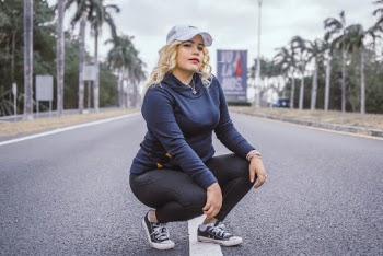 Woman Squatting Between Road