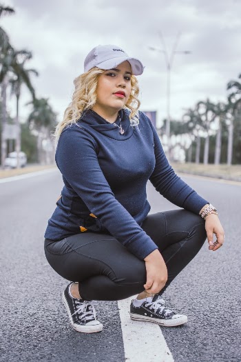 Woman Squatting on Asphalt Road