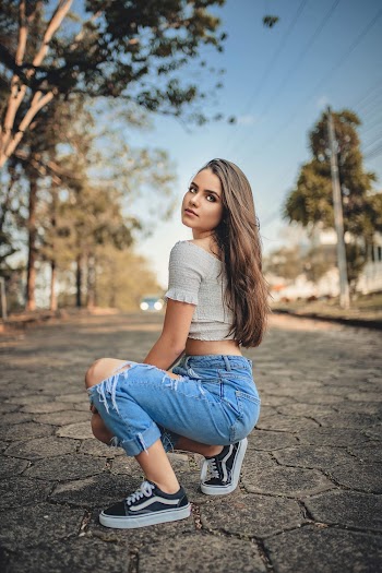 Woman Squatting on Pavement