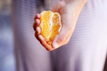 Woman squeezing a fresh, juicy orange. Unporn image collection.