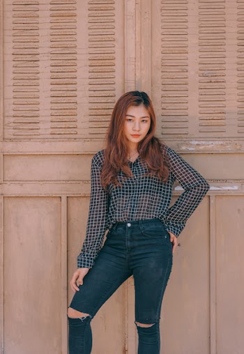 Woman Standing Against Brown Wall