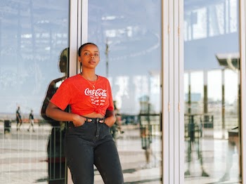Woman Standing Against Glass Wall