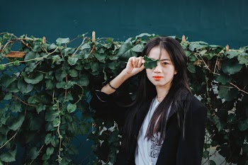 Woman Standing Against Ivy Plant
