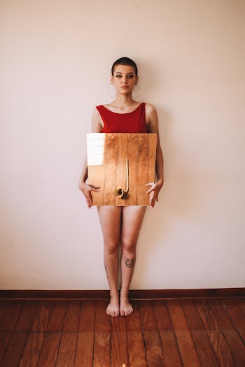 Woman Standing Against Wall Holding Brown Board
