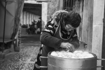 Woman Standing and Arranging Buns