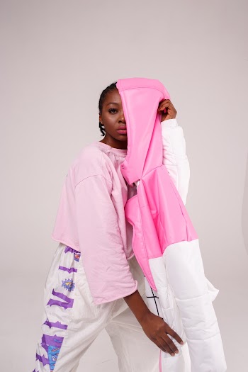 Woman Standing and Covering Half Face Using White and Pink Jacket