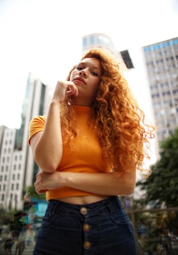 Woman Standing and Putting Right Hand Near Her Chin