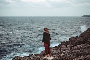 woman standing at seashore cliff