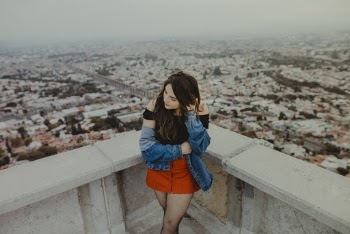 Woman Standing at the Corner of the Top of Building