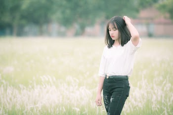 Woman Standing at the Grass Field during Day