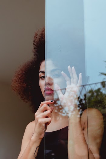 Woman Standing Behind A Glass Wall
