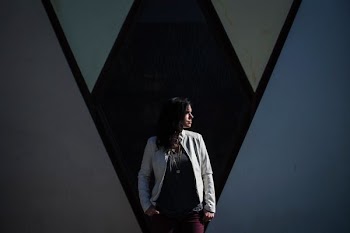woman standing behind black wall while looking right side