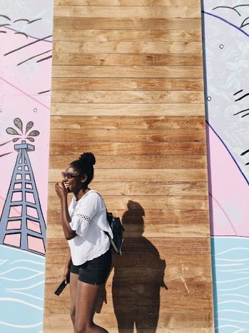 woman standing behind brown wall