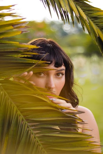 Woman Standing Behind Green Palm Leaves