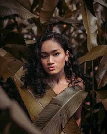 Woman Standing Behind Leaves